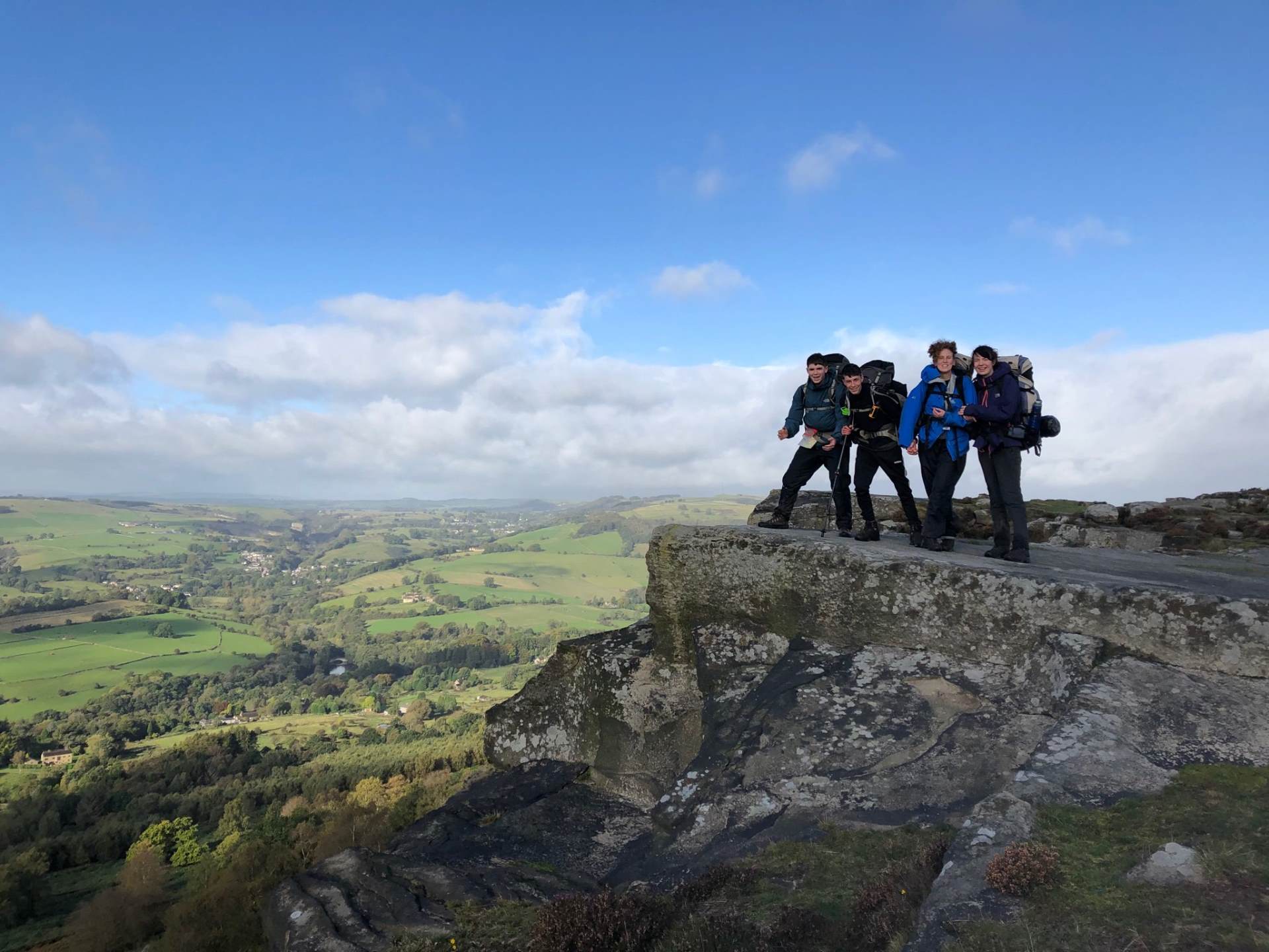 Group of four students atop a rock